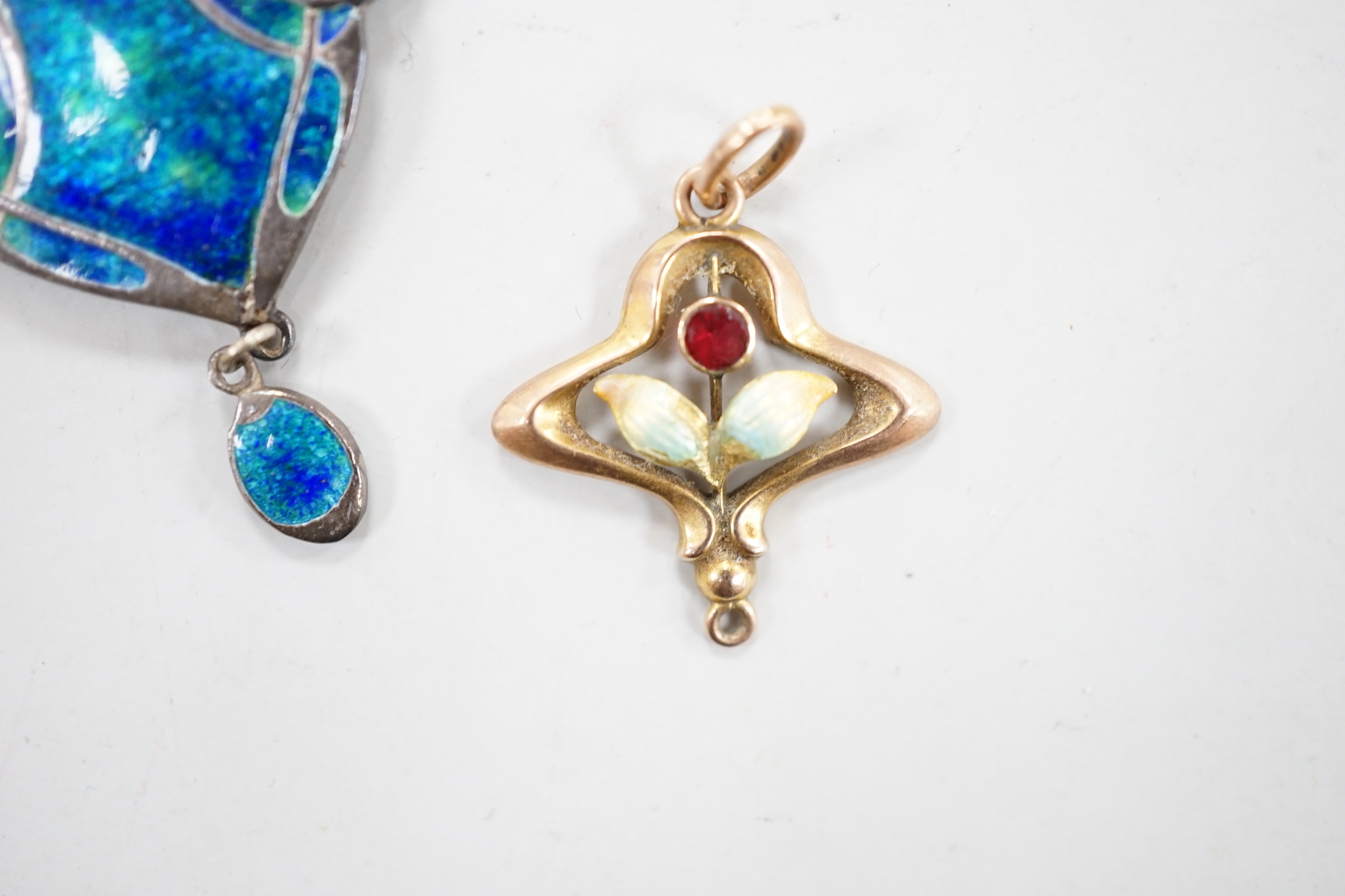 A small 375 yellow metal, enamel and gem set pendant, overall 24mm, gross weight 1 gram and an Art Nouveau 950 white metal and enamel pendant by Murrle Bennet & Co, 35mm, on a white metal chain.